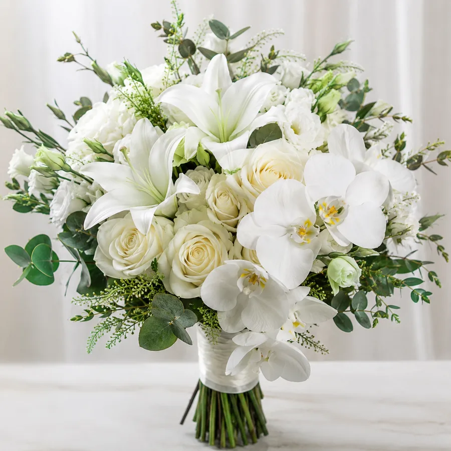 Sympathy arrangement of white lilies, roses and orchids